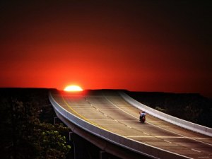 motorcycle-driving-on-empty-highway-in-sunset1